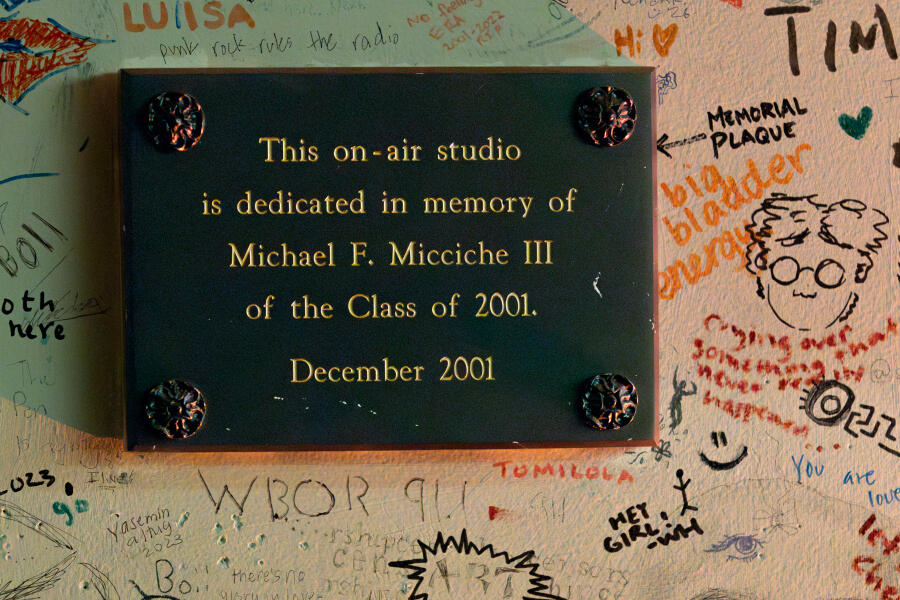 Memorial plaque on a wall surrounded by doodles.