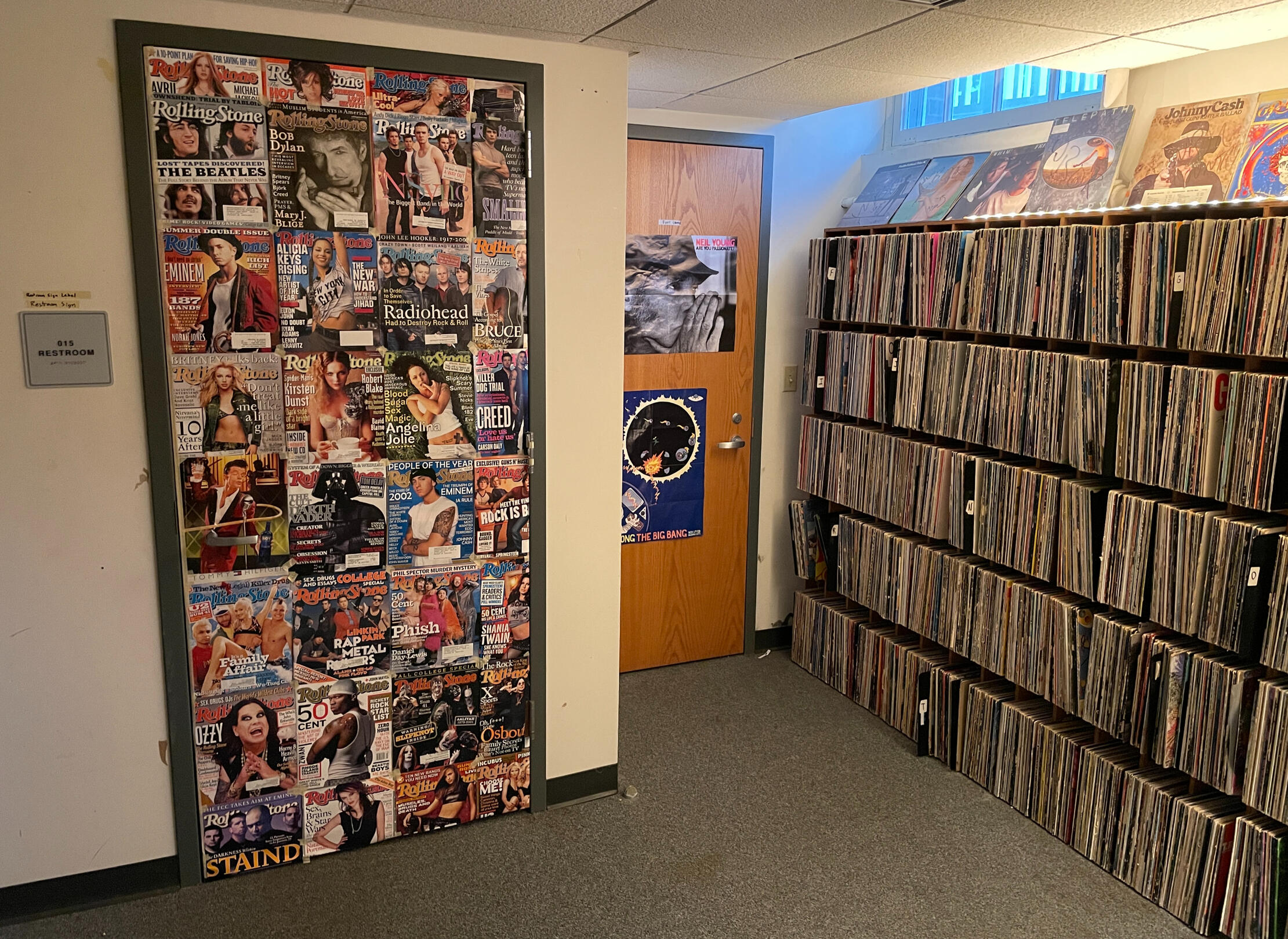 Walls of records, and a bathroom door covered with Rolling Stones Magazine cover pages