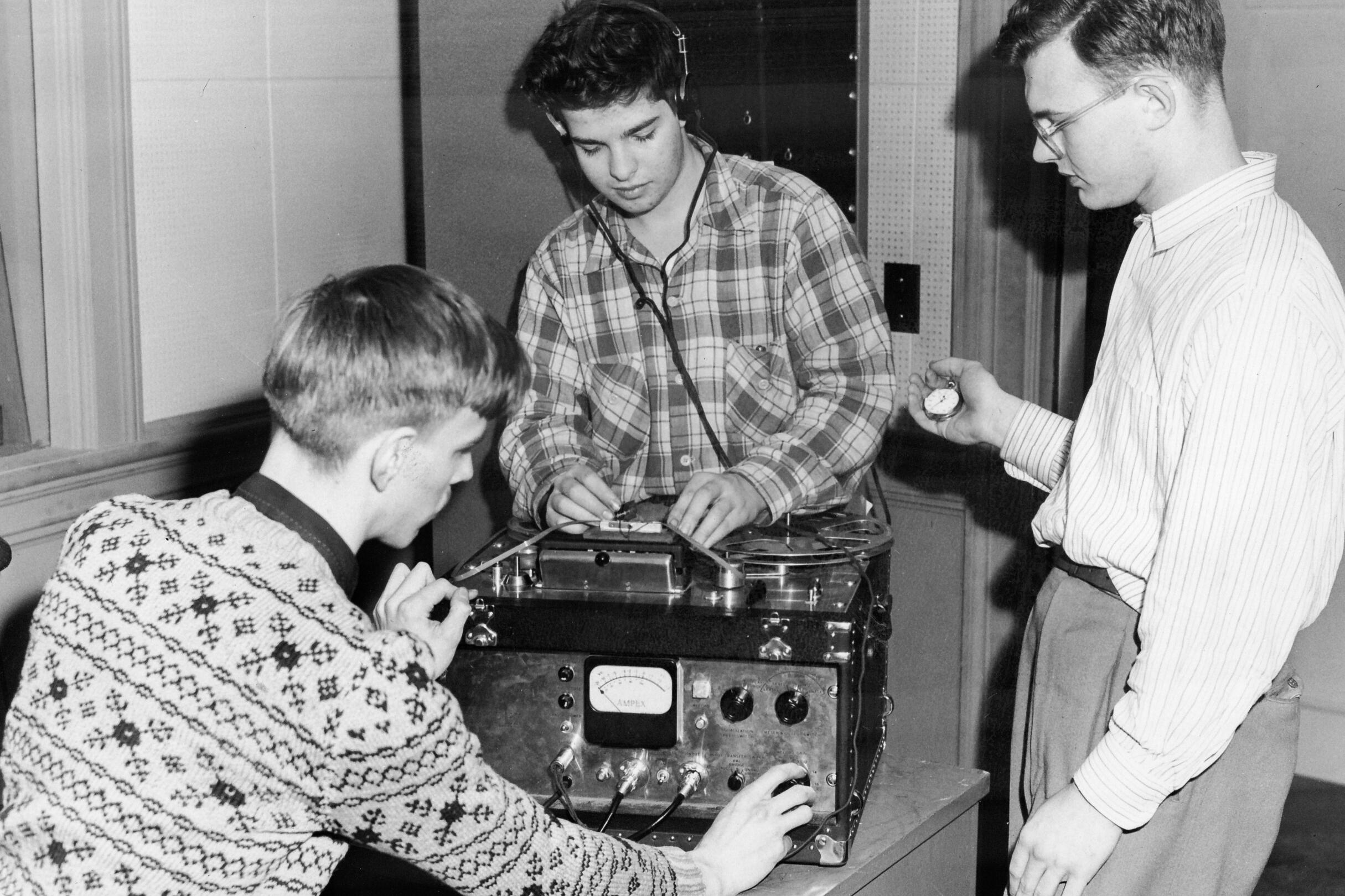 Three students working on broadcast electronics.